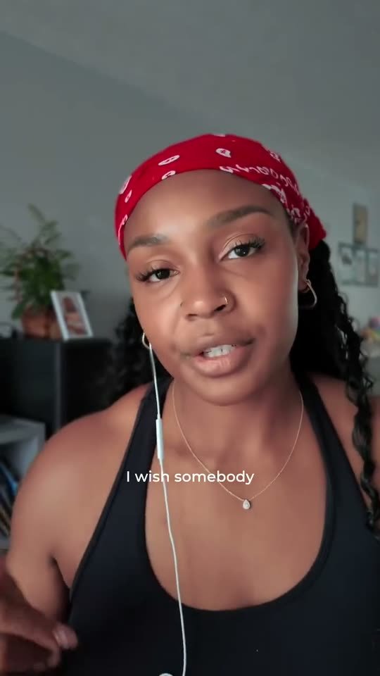 Shana speaking directly to camera in a red bandana